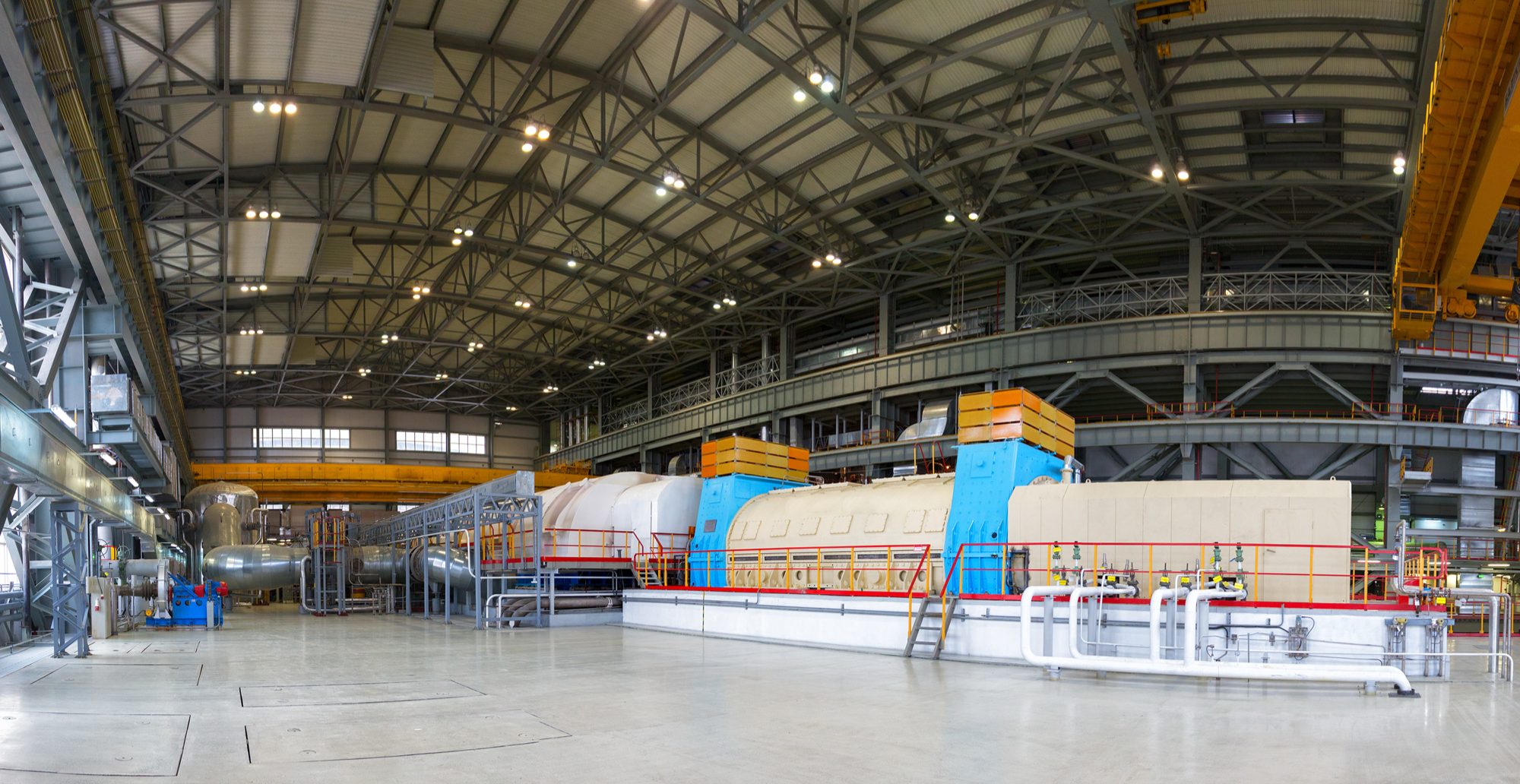 The turbine hall of a nuclear power plant, with a steam turbine running its length under an overhead crane